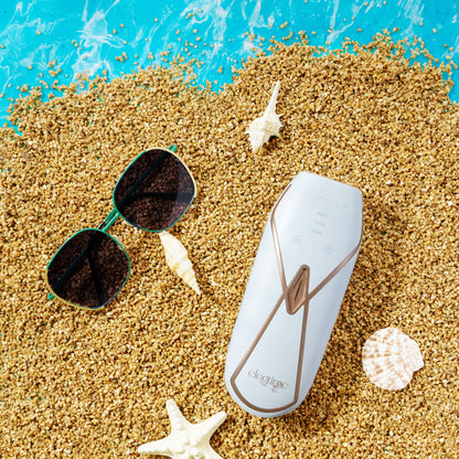  Product image of the Elegtime Sapphire IPL Hair Removal Handset - Troidini Edition featuring summer elements such as bright blue seawater, a starfish, sunglasses, two seashells, a shell, and sand on the beach.
